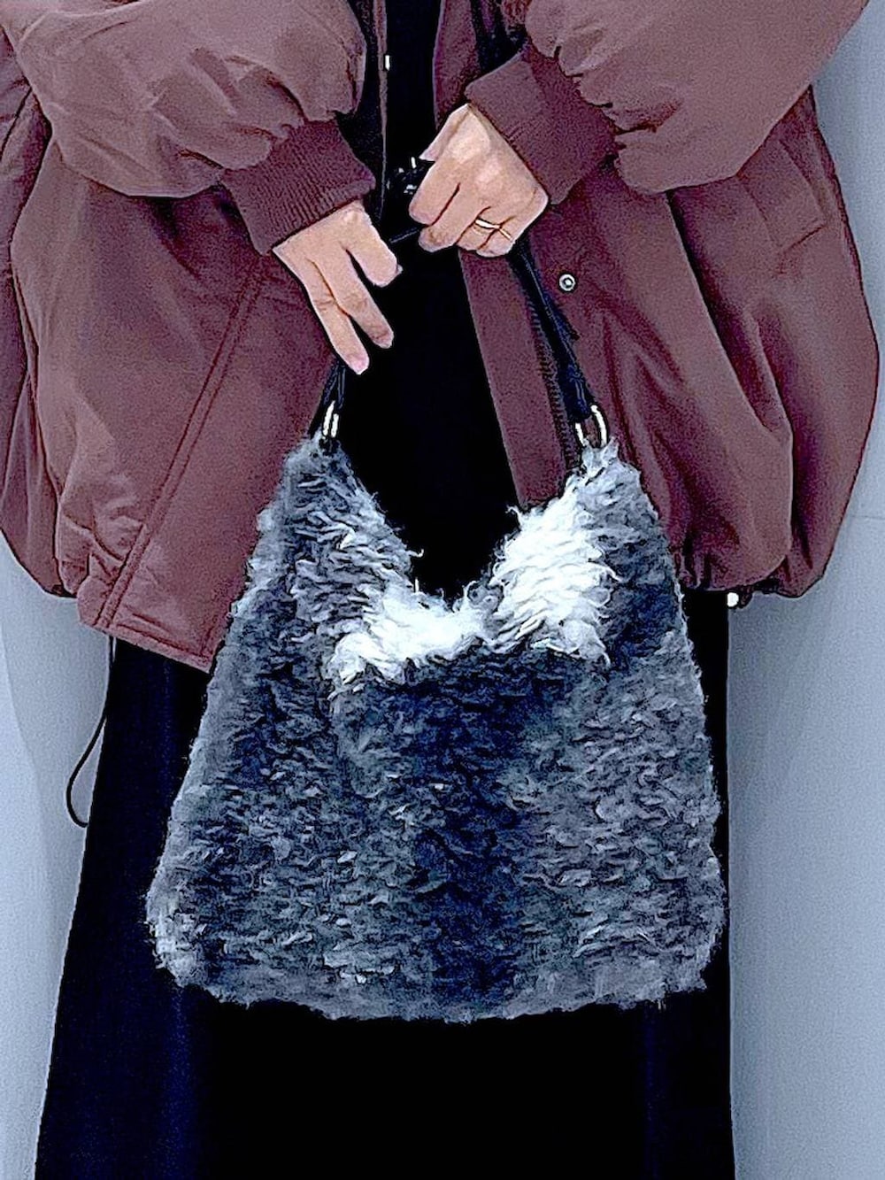 ブラウン系のブルゾン、ブラック系のブーツ、ブラック系のショルダーバッグを着用したレディースの冬コーディネートの9枚目の写真