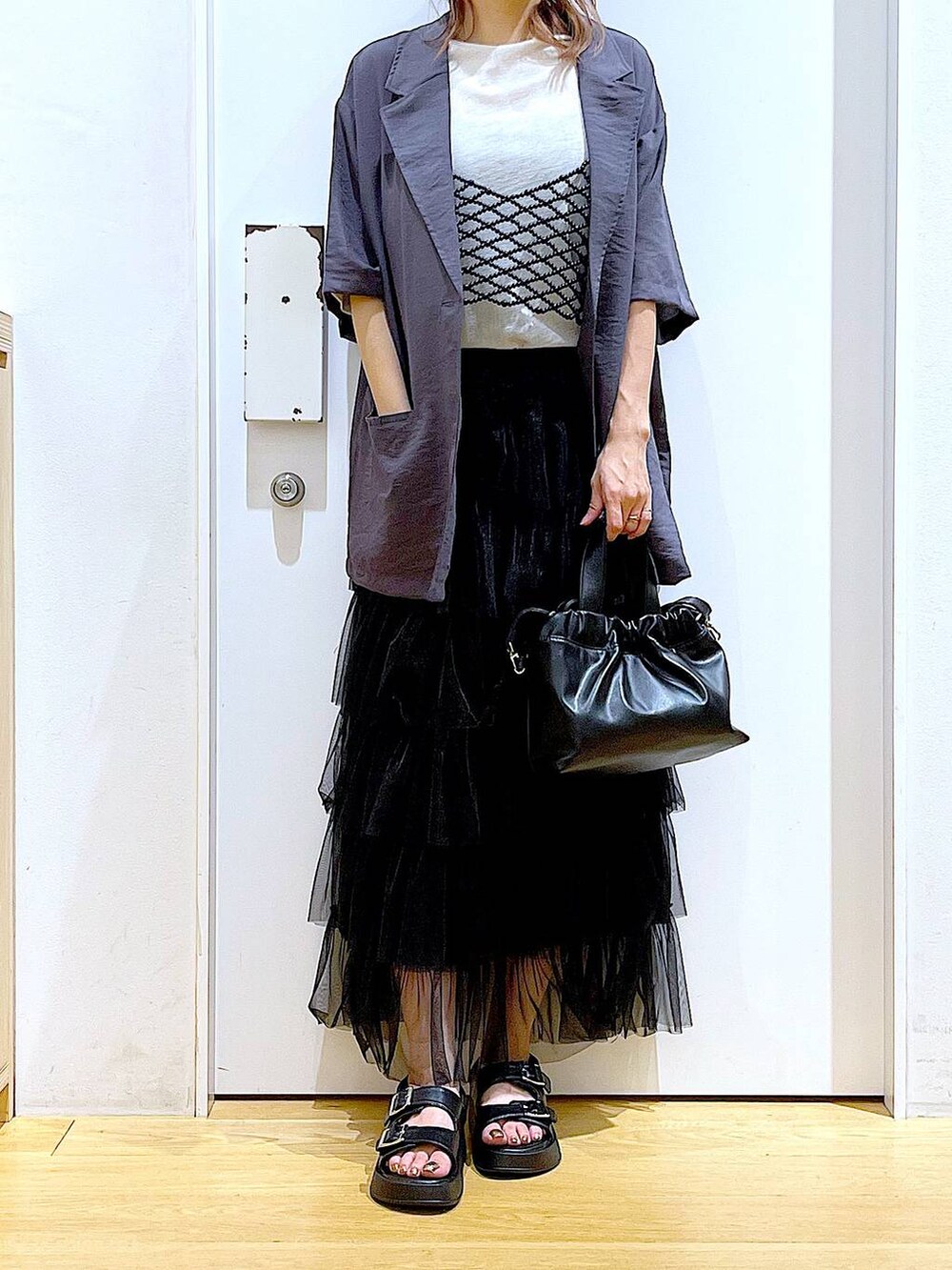 ブラック系のサンダル、ブラック系のショルダーバッグ、ブラック系のスカートを着用したレディースの夏コーディネートの6枚目の写真