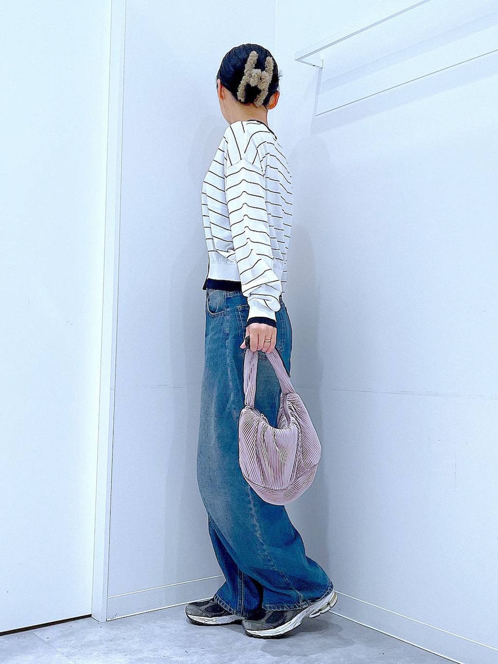 ブルー系のデニムパンツ、ピンク系のショルダーバッグ、ホワイト系のカーディガン/ボレロを着用したレディースの春コーディネートの3枚目の写真