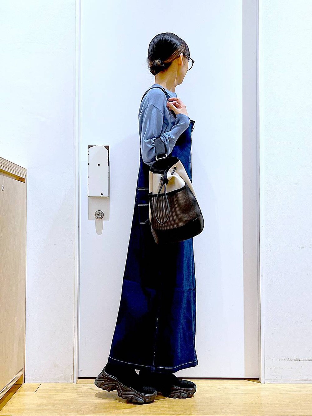 ブルー系のジャンパースカート、ブルー系のカーディガン/ボレロ、ブラック系のブーツを着用したレディースの春コーディネートの4枚目の写真