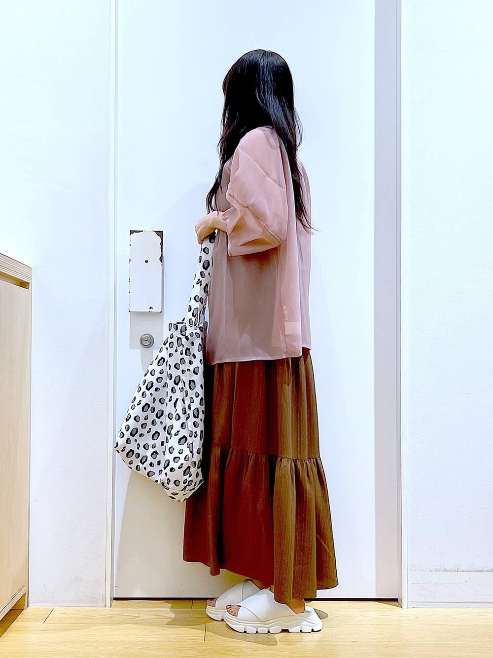 ホワイト系のサンダル、ベージュ系のワンピース、ホワイト系のトートバッグを着用したレディースの夏コーディネートの3枚目の写真