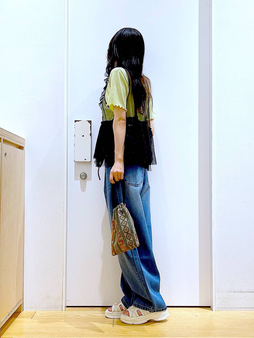 ブラウン系のショルダーバッグ、ホワイト系のサンダル、ブルー系のデニムパンツを着用したレディースの夏コーディネートの4枚目の写真