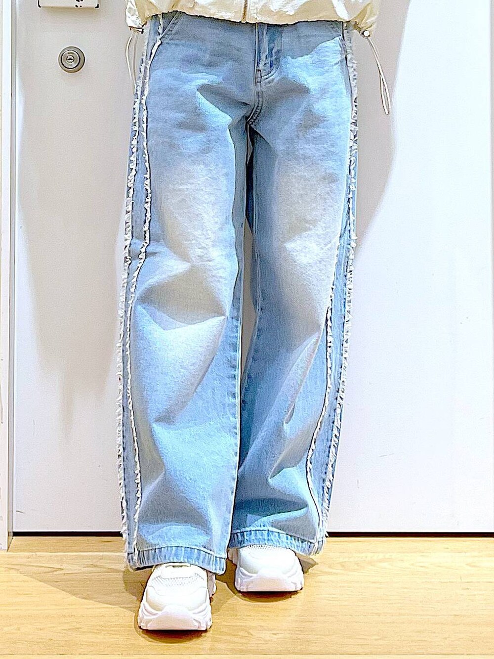 ホワイト系のスニーカー、ブルー系のデニムパンツ、ホワイト系のブルゾンを着用したレディースの春コーディネートの8枚目の写真