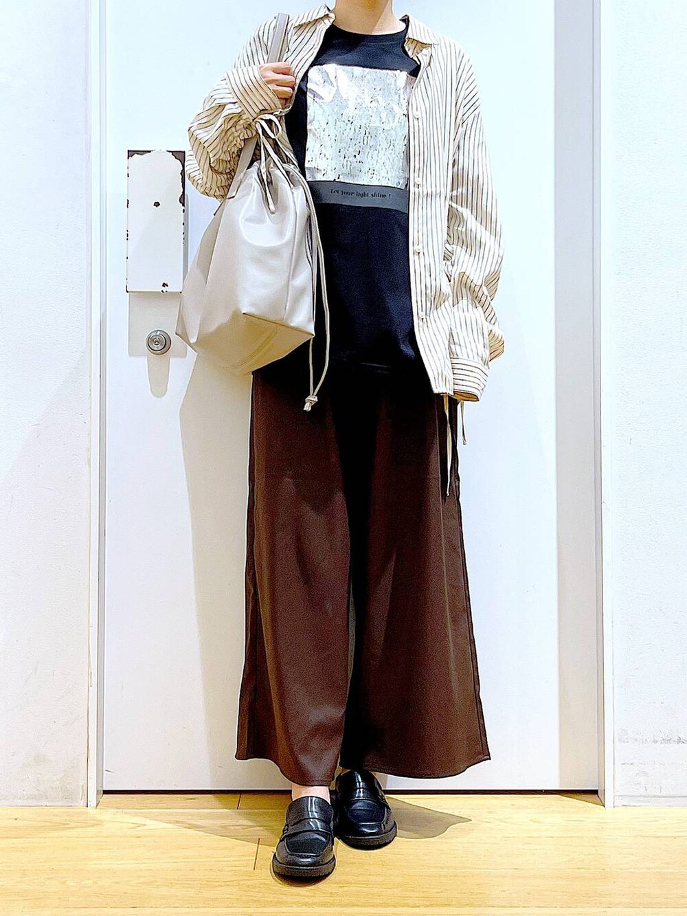 ベージュ系のトートバッグ、ブラック系のローファー、ブラウン系のその他パンツを着用したレディースの秋コーディネートの6枚目の写真