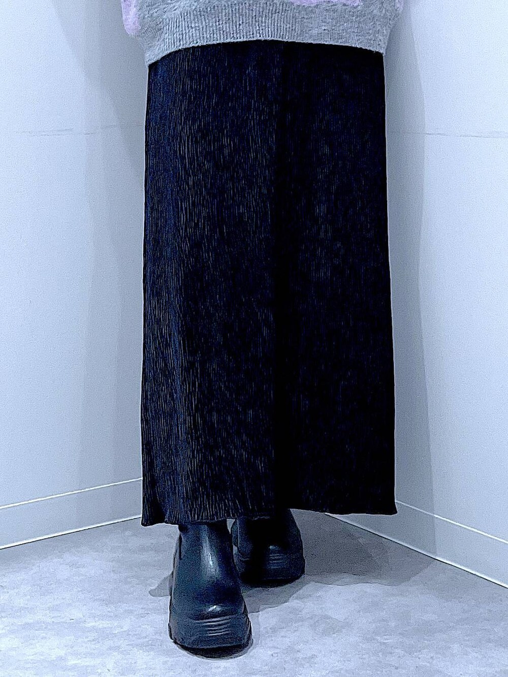 ブラック系のブーツ、グレー系のニット/セーター、ブラック系のスカートを着用したレディースの冬コーディネートの8枚目の写真