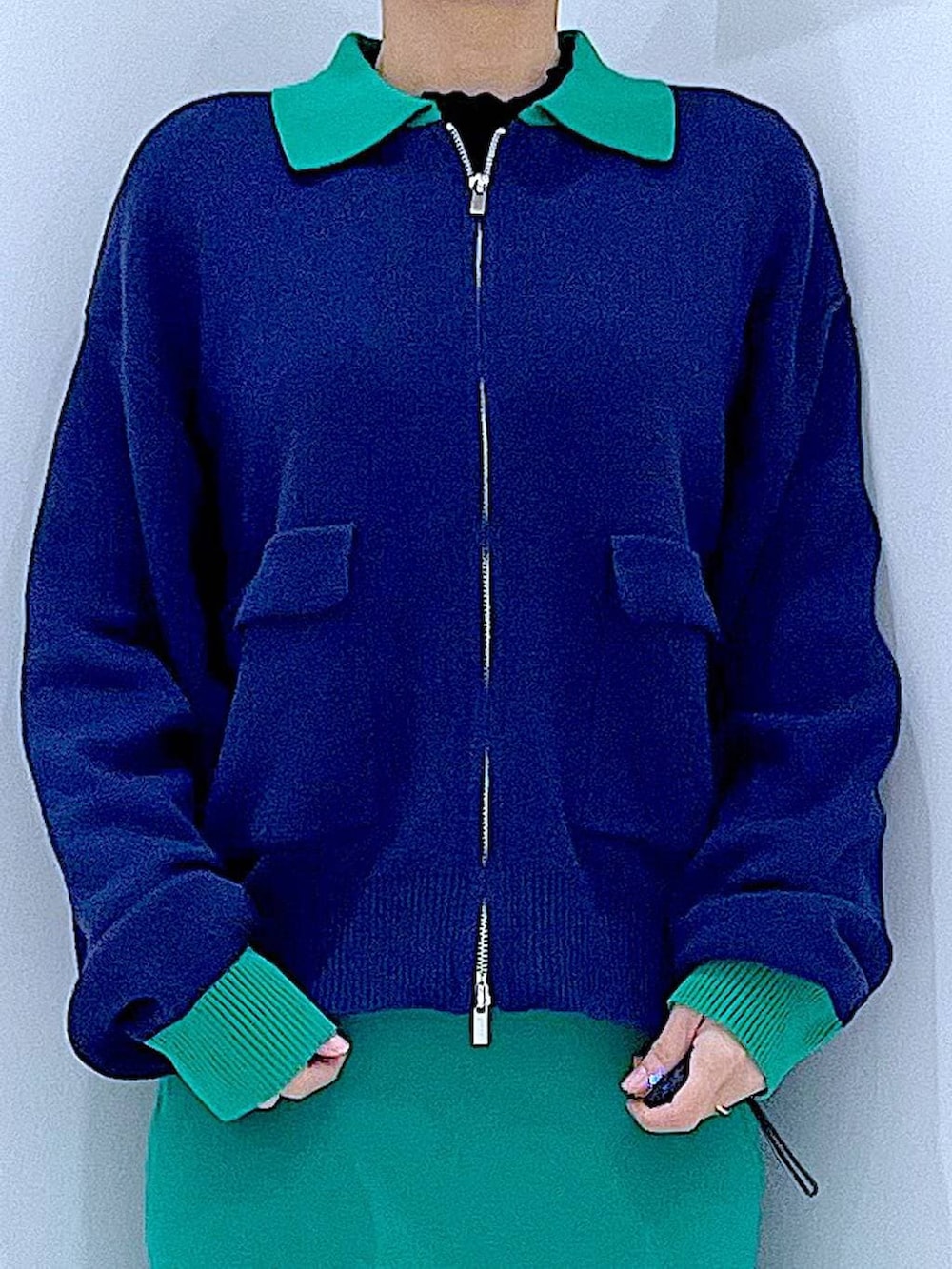 ブラック系のショルダーバッグ、ブルー系のカーディガン/ボレロ、グリーン系のスカートを着用したレディースの春コーディネートの7枚目の写真