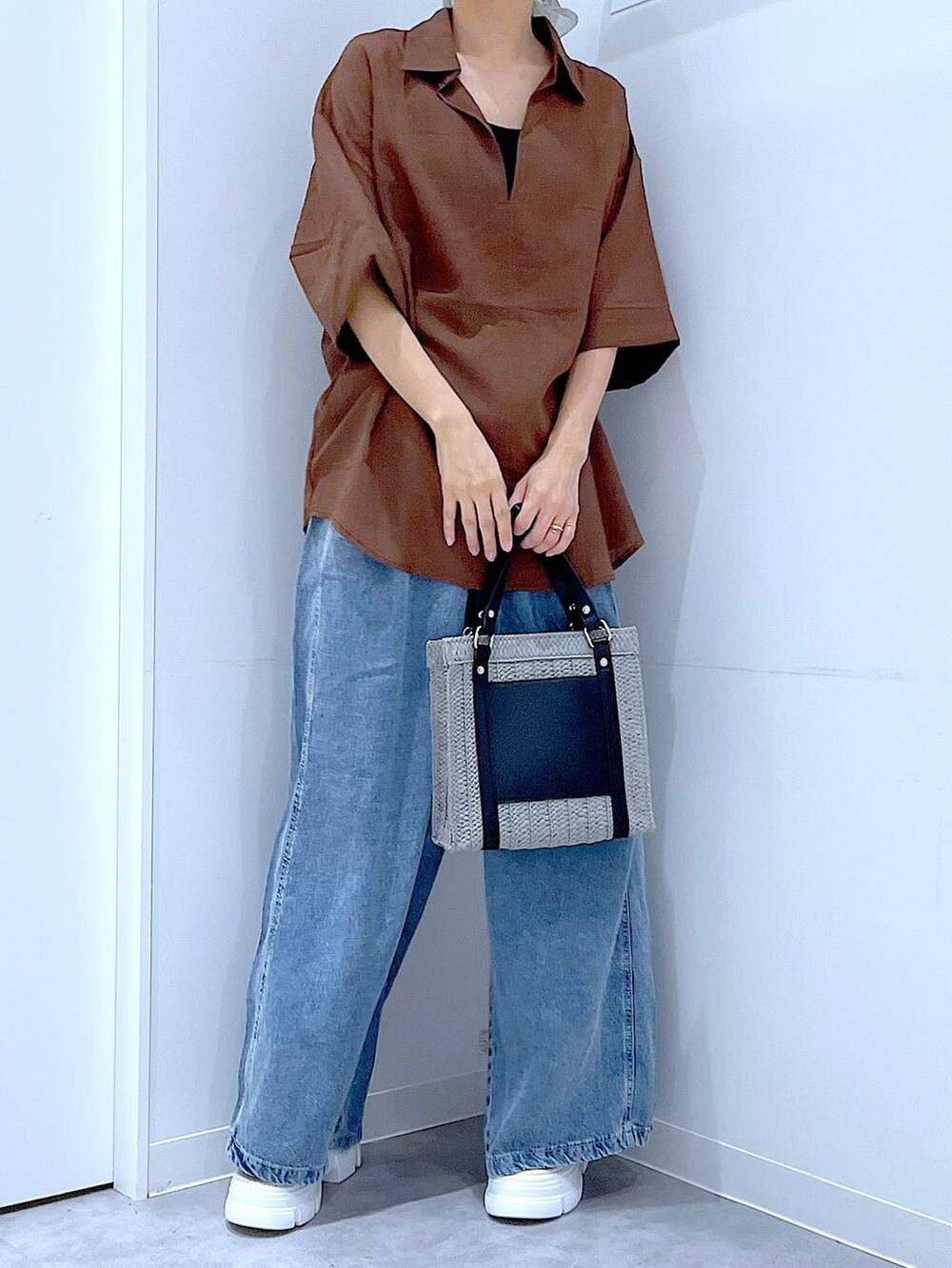 グレー系のショルダーバッグ、ホワイト系のサンダル、ブルー系のデニムパンツを着用したレディースの夏コーディネートの6枚目の写真
