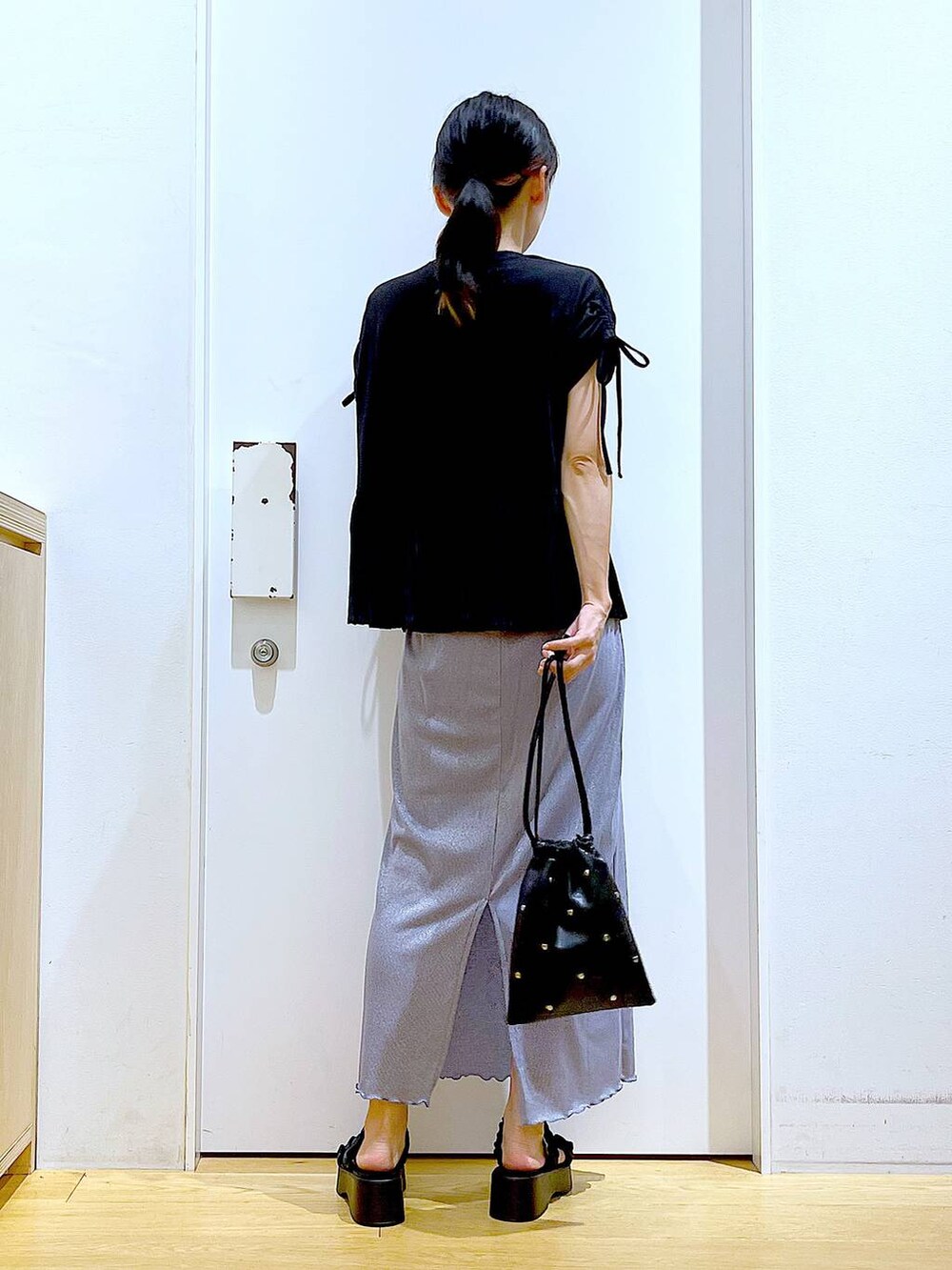 パープル系のスカート、ブラック系のショルダーバッグ、ブラック系のサンダルを着用したレディースの夏コーディネートの5枚目の写真