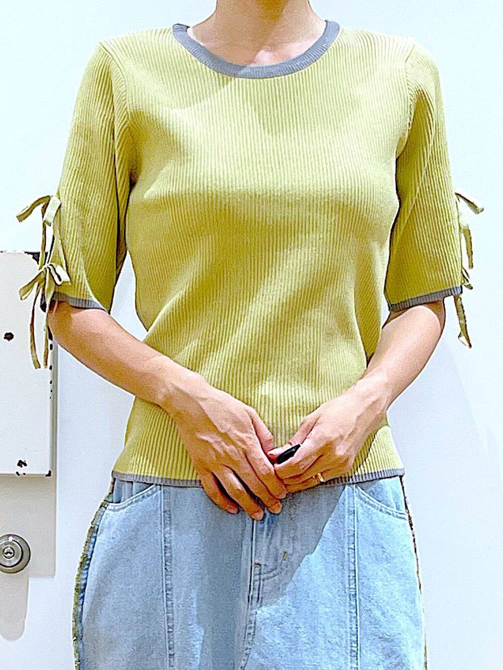 ベージュ系のトートバッグ、シルバー系のローファー、イエロー系のニット/セーターを着用したレディースの秋コーディネートの7枚目の写真