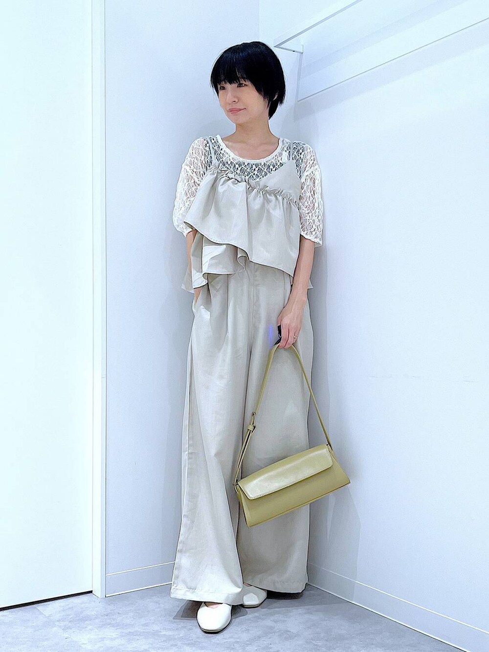 ホワイト系のパンプス、イエロー系のショルダーバッグ、ホワイト系のTシャツ/カットソーを着用したレディースの夏コーディネートの2枚目の写真