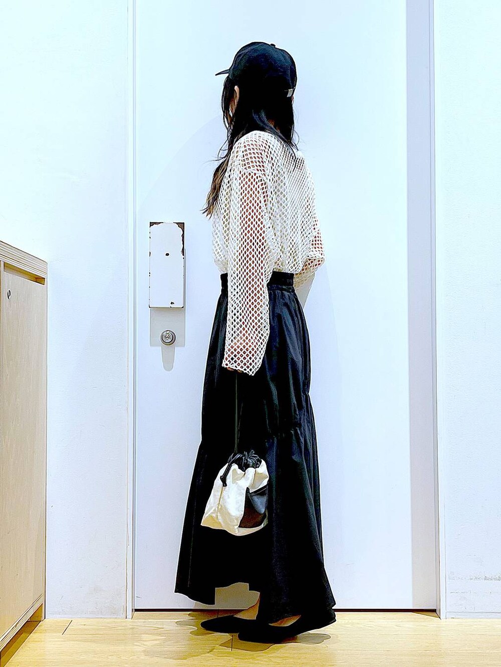 ホワイト系のTシャツ/カットソー、ホワイト系のショルダーバッグ、イエロー系のニット/セーターを着用したレディースの春コーディネートの3枚目の写真