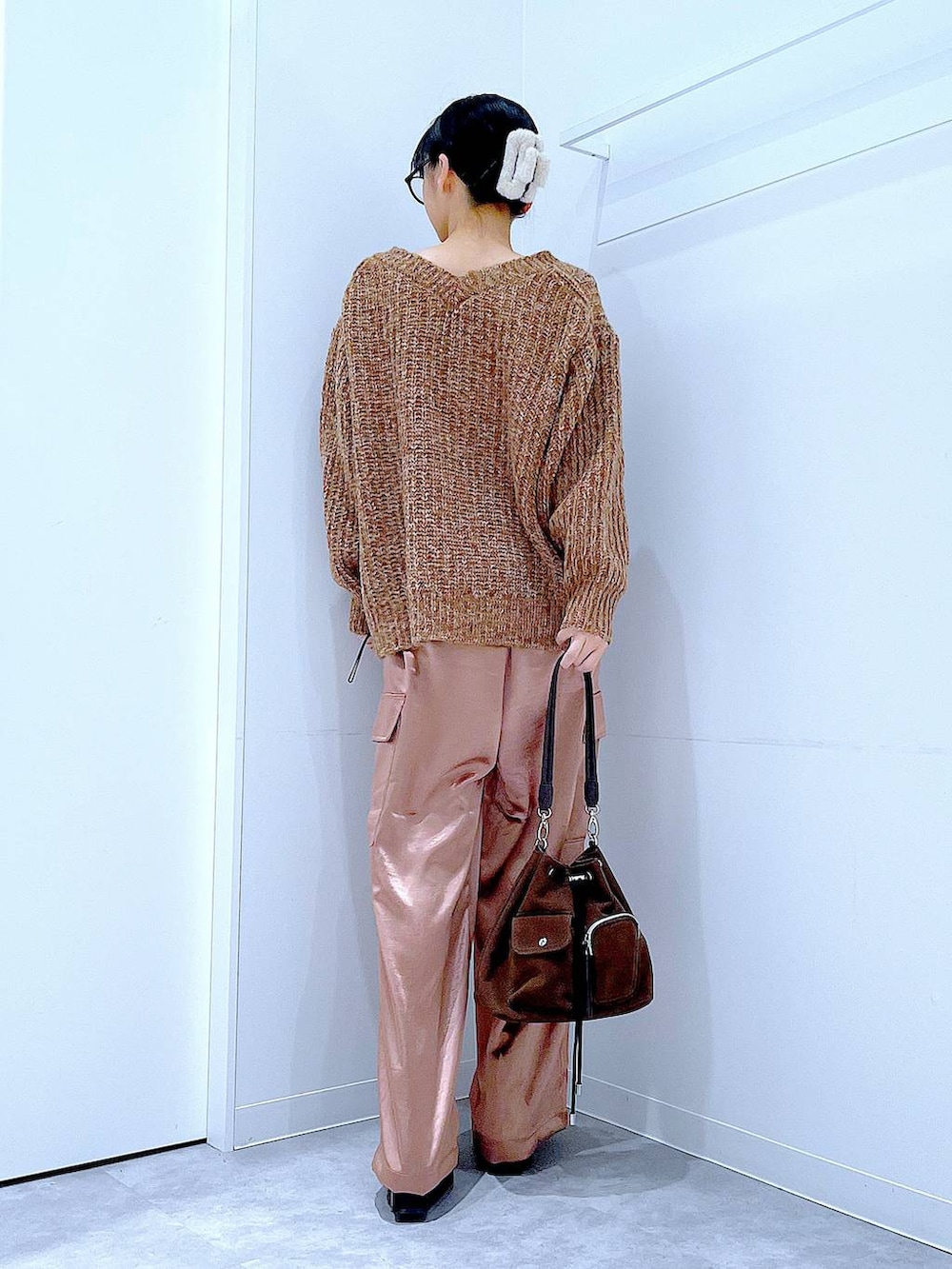 ブラウン系のニット/セーター、ブラウン系のショルダーバッグ、ブラック系のブーツを着用したレディースの冬コーディネートの5枚目の写真