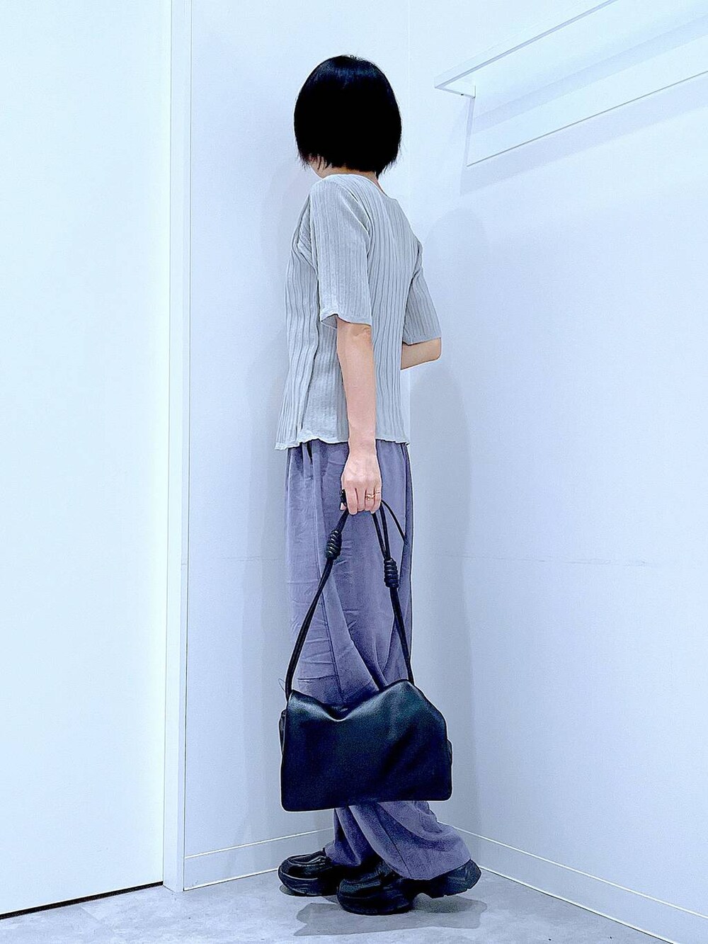 ブラック系のショルダーバッグ、ブラック系のローファー、グレー系のニット/セーターを着用したレディースの秋コーディネートの3枚目の写真