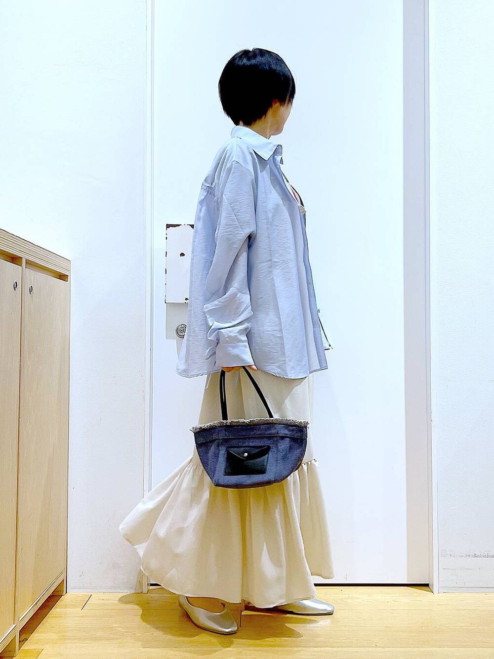 シルバー系のパンプス、ブルー系のショルダーバッグ、ブルー系のシャツ/ブラウスを着用したレディースの春コーディネートの4枚目の写真