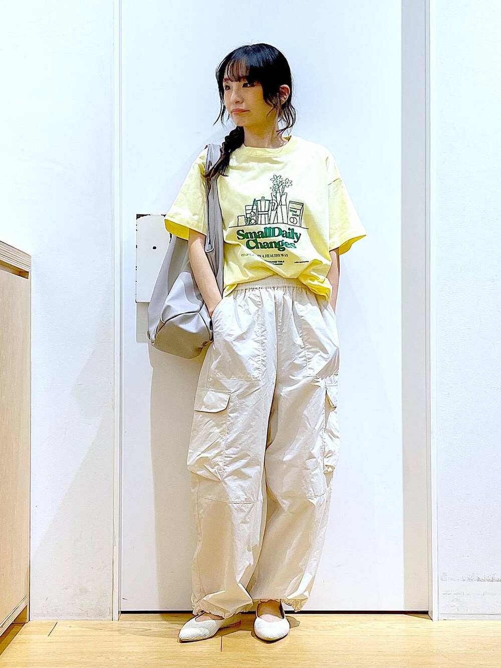 グレー系のトートバッグ、ホワイト系のカーゴパンツ、ホワイト系のパンプスを着用したレディースの春コーディネートの2枚目の写真