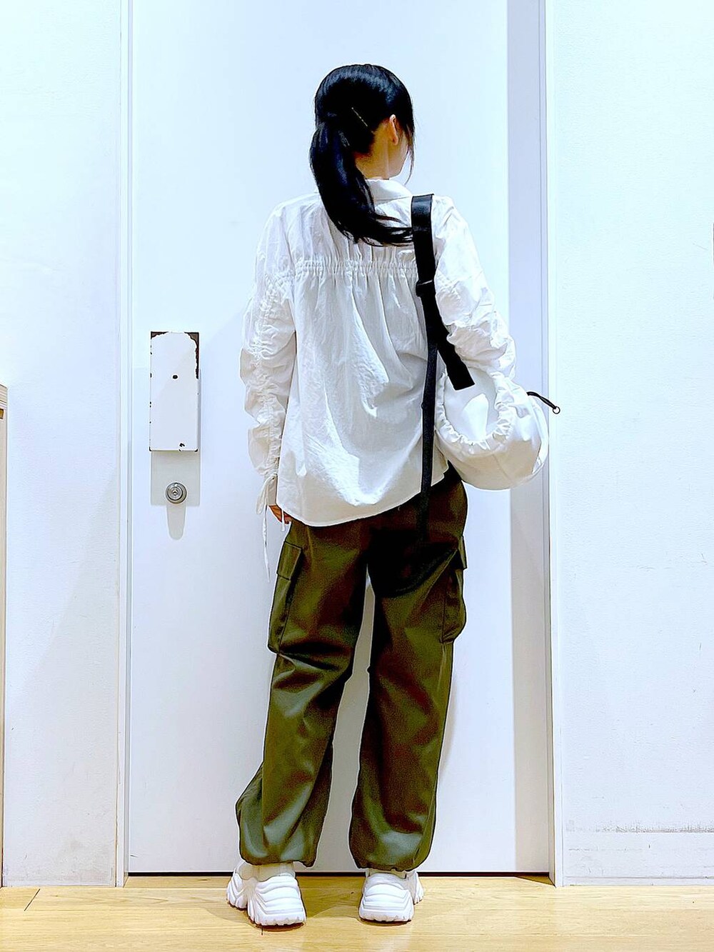 ホワイト系のシャツ/ブラウス、ホワイト系のショルダーバッグ、ベージュ系のスニーカーを着用したレディースの春コーディネートの5枚目の写真