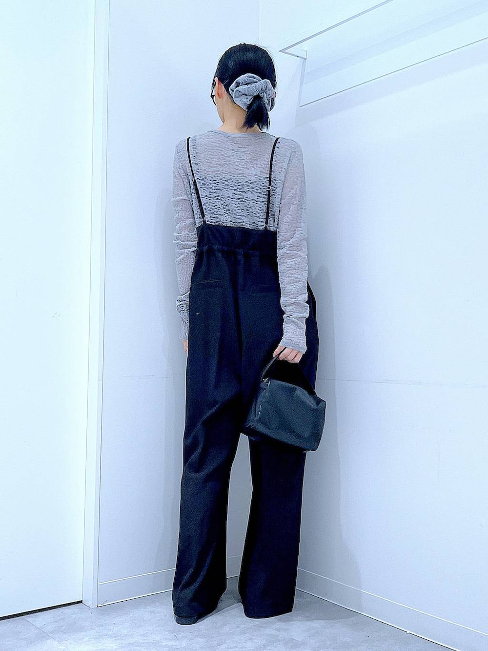 ブラック系のショルダーバッグ、ブラック系のローファー、ブラック系のサロペット/オーバーオールを着用したレディースの冬コーディネートの5枚目の写真