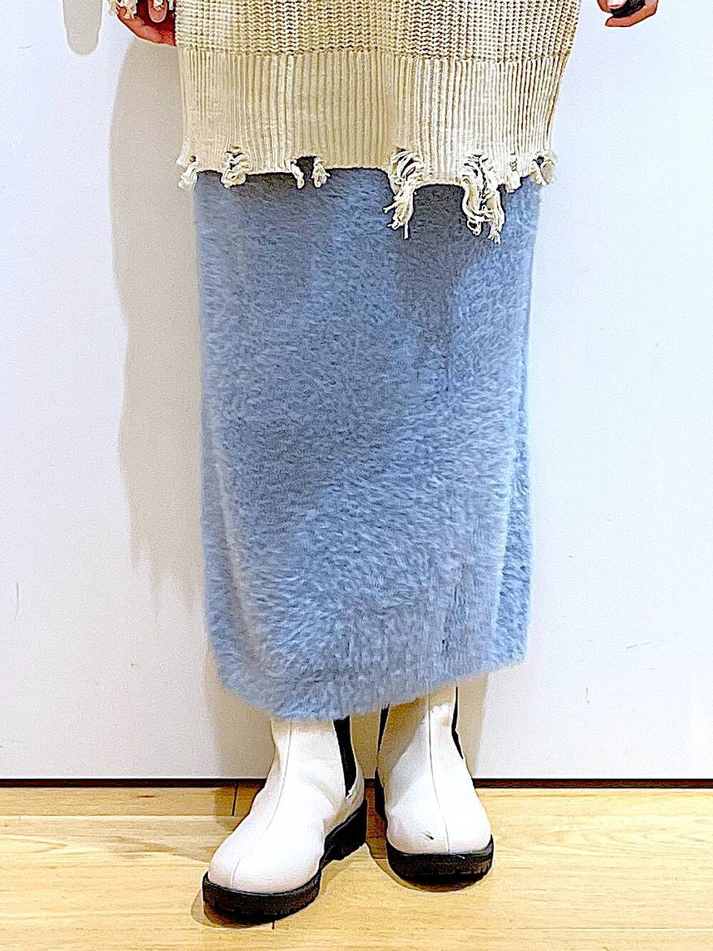 ベージュ系のブーツ、その他のトートバッグ、ブルー系のスカートを着用したレディースの冬コーディネートの8枚目の写真