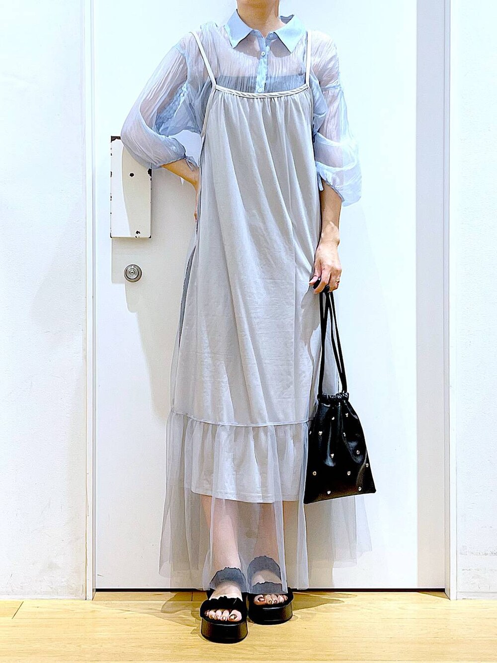 ブラック系のサンダル、ブラック系のショルダーバッグ、ブルー系のシャツ/ブラウスを着用したレディースの夏コーディネートの6枚目の写真