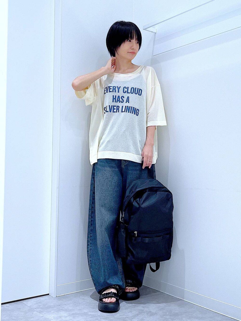 ブルー系のデニムパンツ、ブラック系のバックパック/リュック、ブラック系のサンダルを着用したレディースの夏コーディネートの2枚目の写真