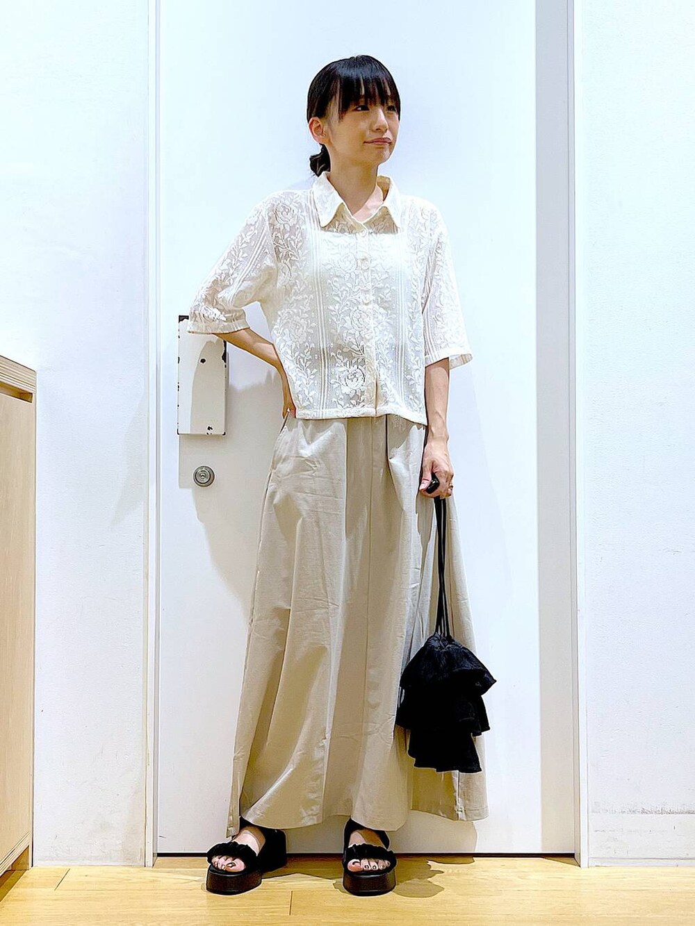 ブラック系のサンダル、ベージュ系のシャツ/ブラウス、ベージュ系のスカートを着用したレディースの夏コーディネートの2枚目の写真