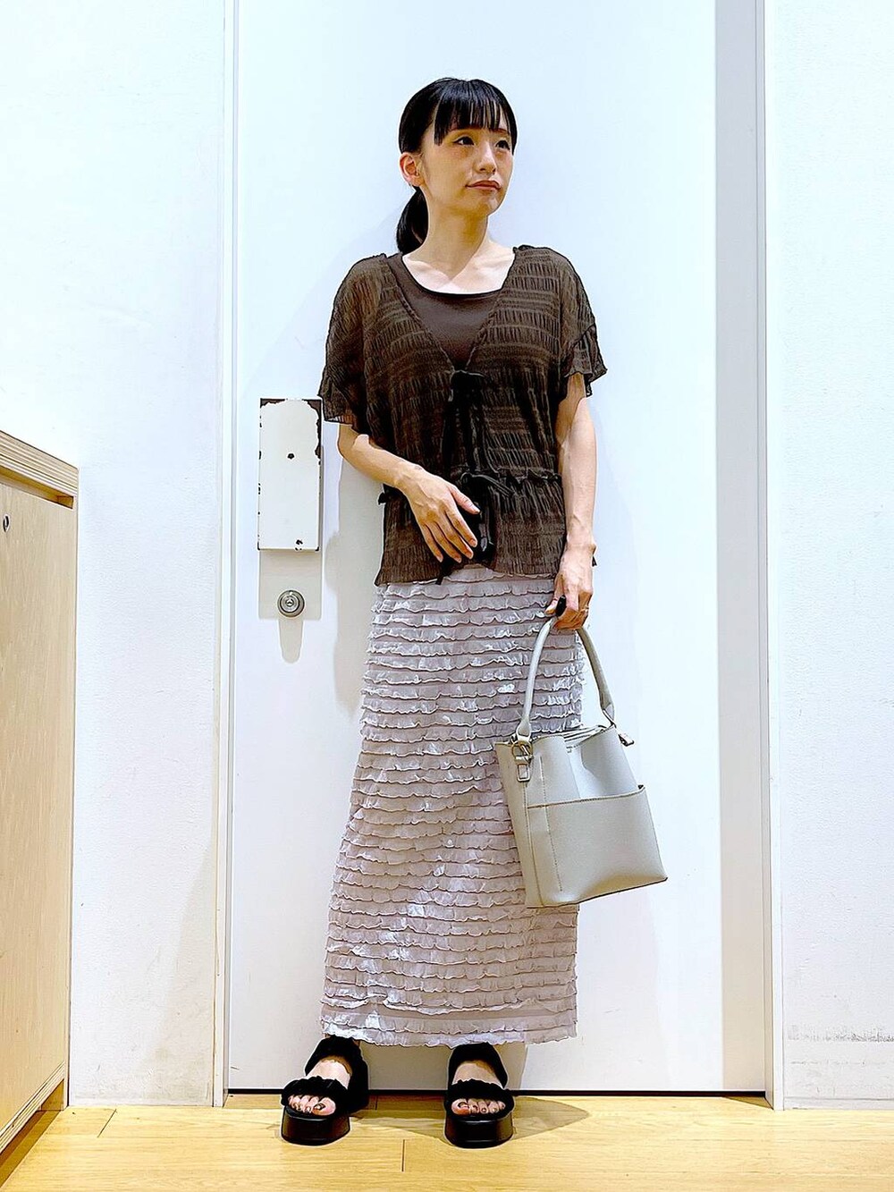 ブラック系のサンダル、グレー系のショルダーバッグ、グレー系のスカートを着用したレディースの秋コーディネートの2枚目の写真