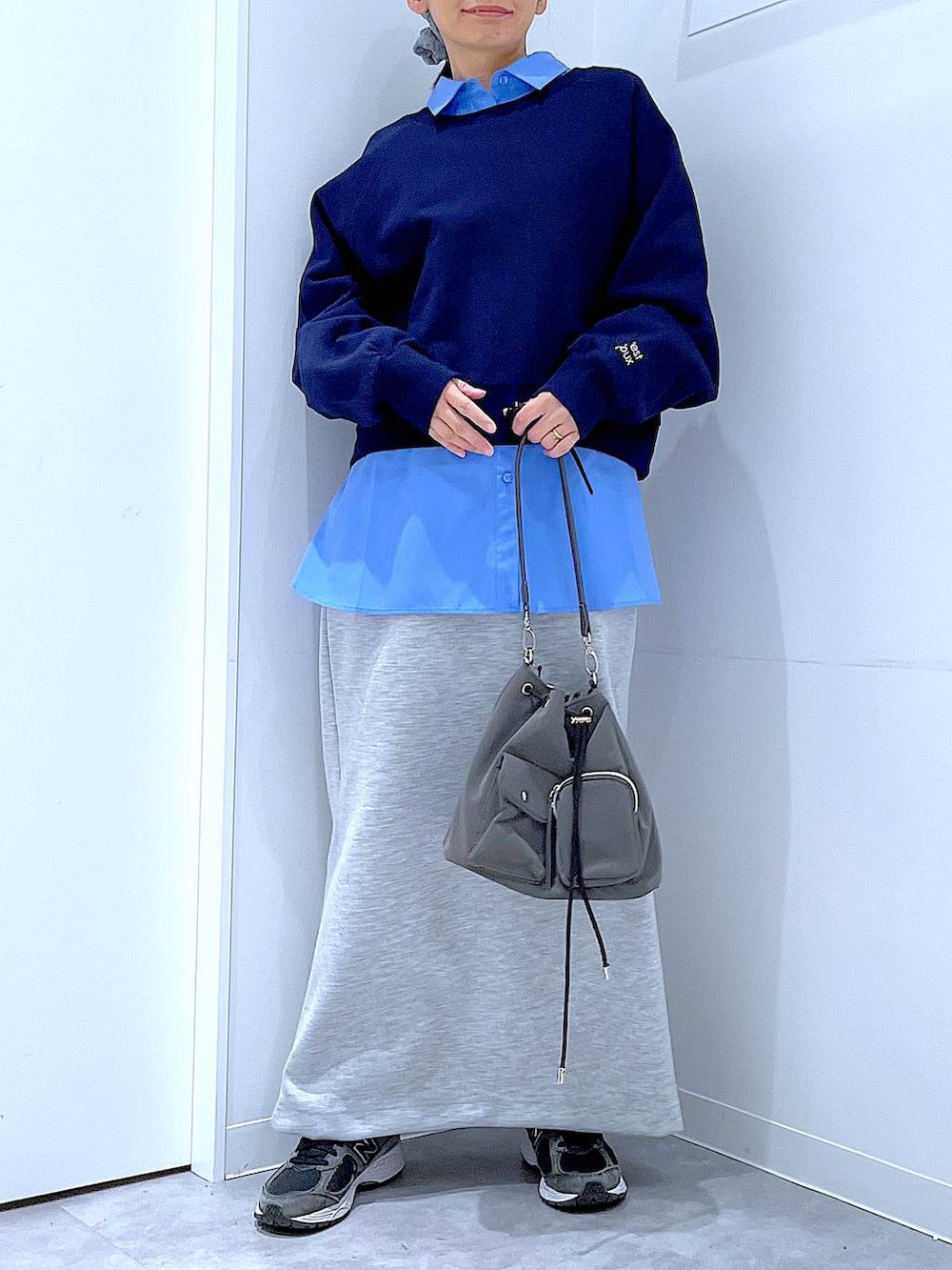 グレー系のショルダーバッグ、グレー系のスカート、ブルー系のシャツ/ブラウスを着用したレディースの春コーディネートの6枚目の写真
