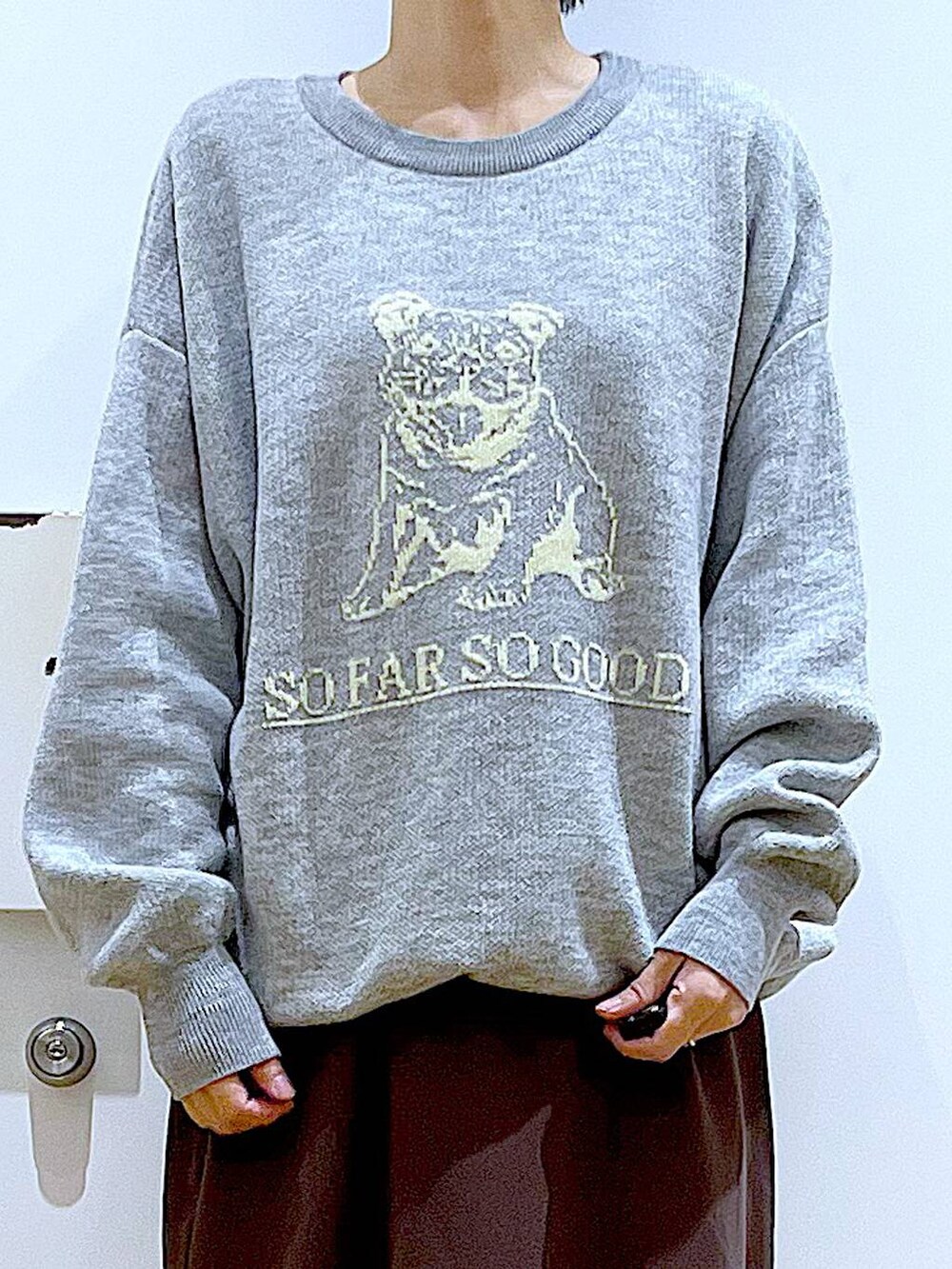 ブラック系のブーツ、ピンク系のトートバッグ、ブラウン系のスカートを着用したレディースの冬コーディネートの7枚目の写真