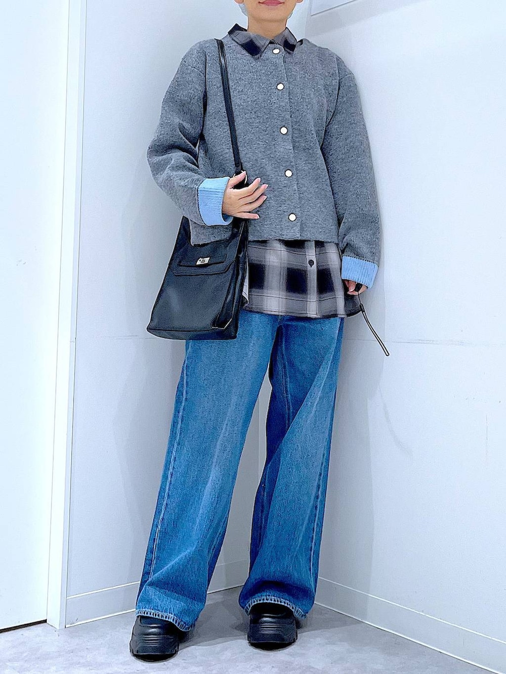 ブルー系のデニムパンツ、ブラック系のシャツ/ブラウス、ブラック系のショルダーバッグを着用したレディースの秋コーディネートの6枚目の写真