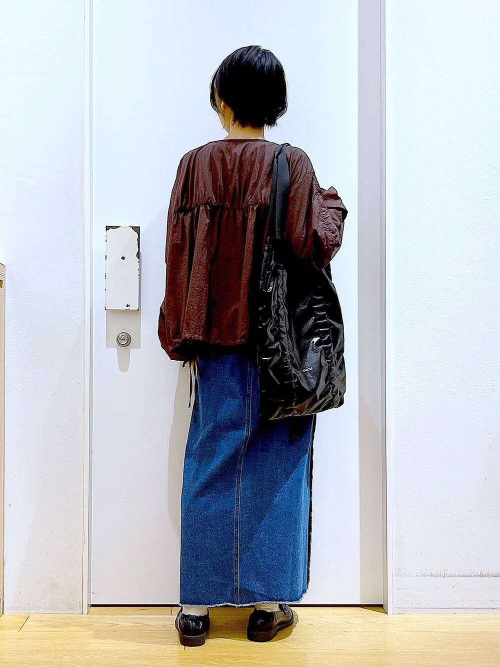 ブラック系のローファー、ブルー系のデニムスカート、ブラック系のTシャツ/カットソーを着用したレディースの秋コーディネートの5枚目の写真