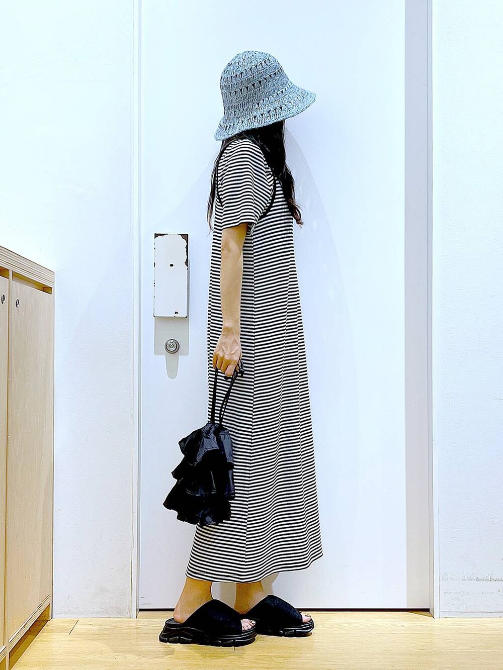 ブラック系のショルダーバッグ、ブラック系のサンダル、ブラック系のワンピースを着用したレディースの夏コーディネートの4枚目の写真