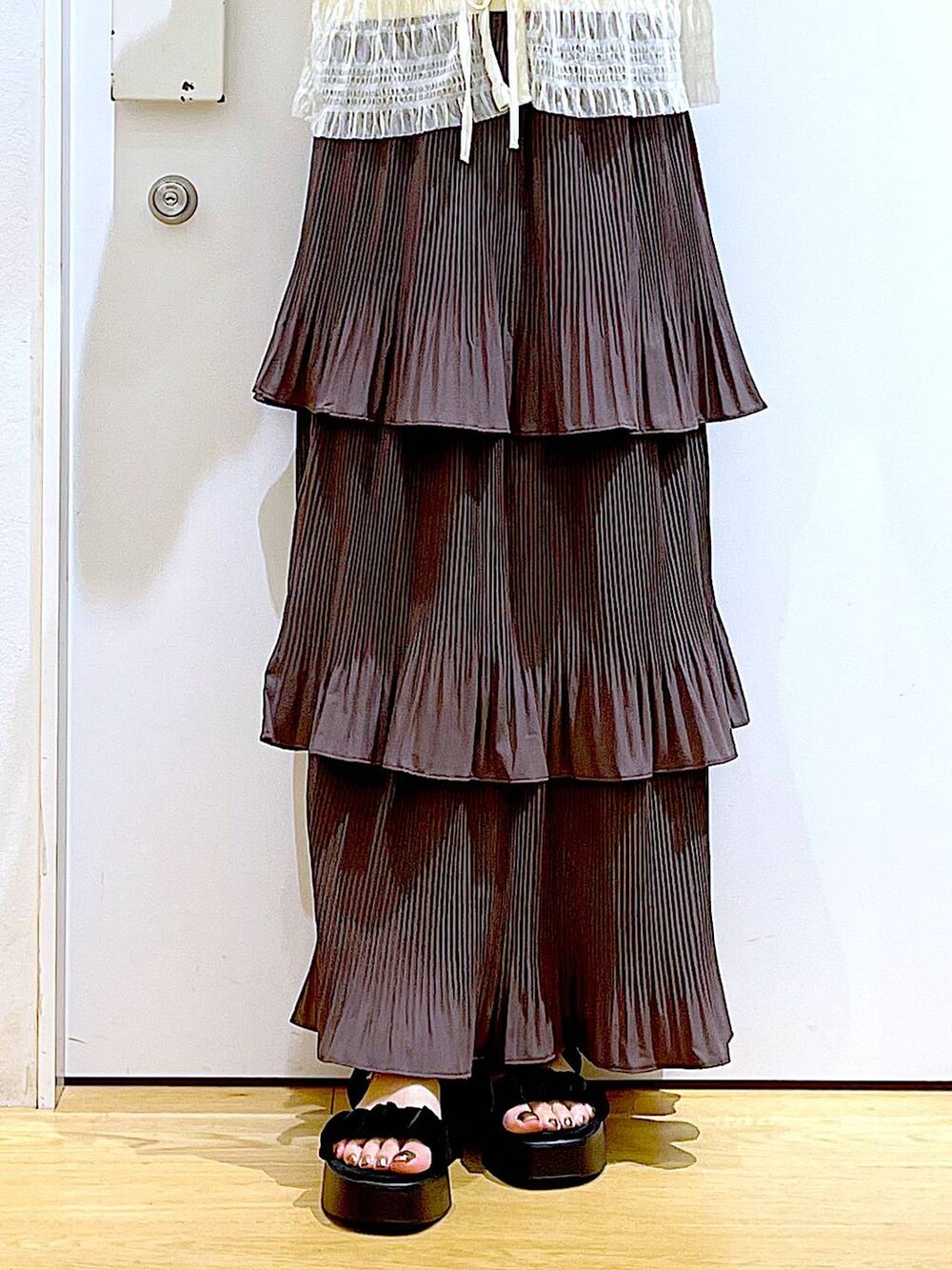 ブラウン系のスカート、ブラック系のサンダル、ホワイト系のカーディガン/ボレロを着用したレディースの夏コーディネートの8枚目の写真