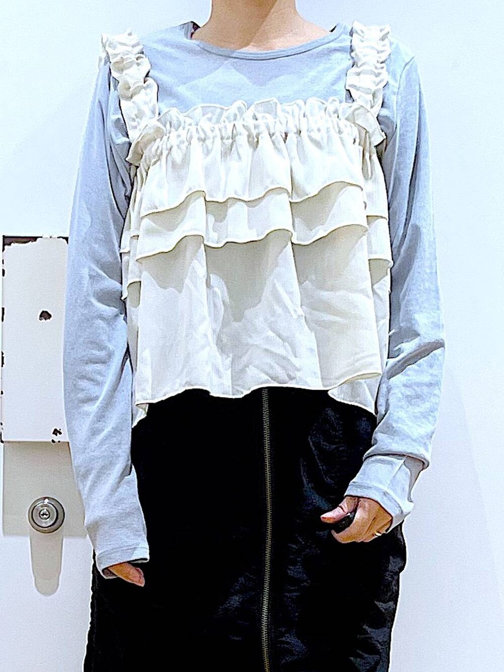 ブラック系のスカート、ブラック系のショルダーバッグ、ホワイト系のスニーカーを着用したレディースの春コーディネートの7枚目の写真