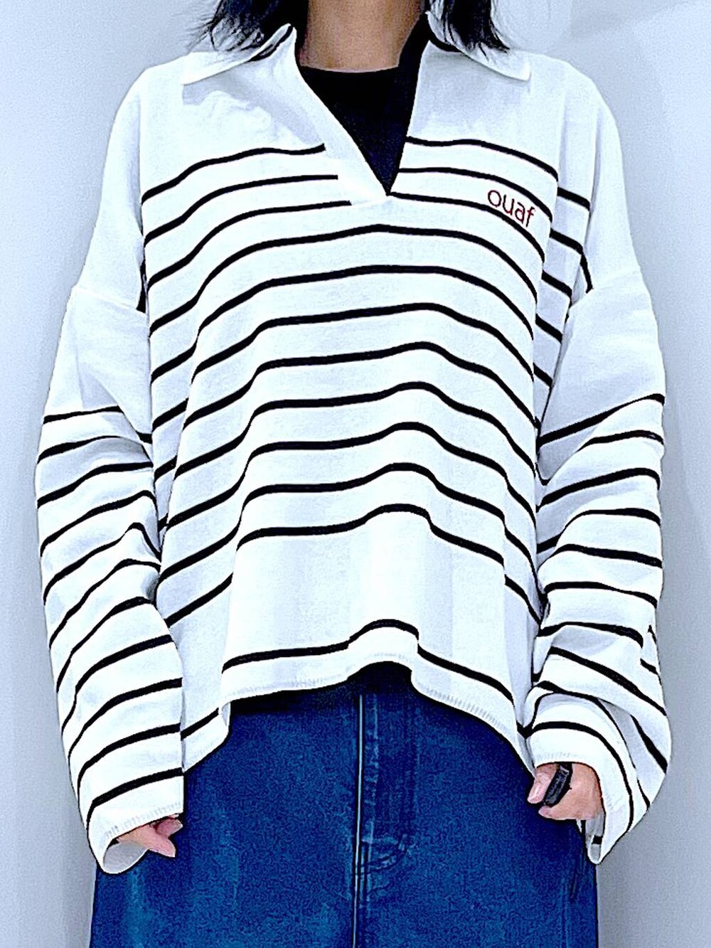 ブラック系のTシャツ/カットソー、ベージュ系のトートバッグ、ブルー系のデニムパンツを着用したレディースの冬コーディネートの7枚目の写真