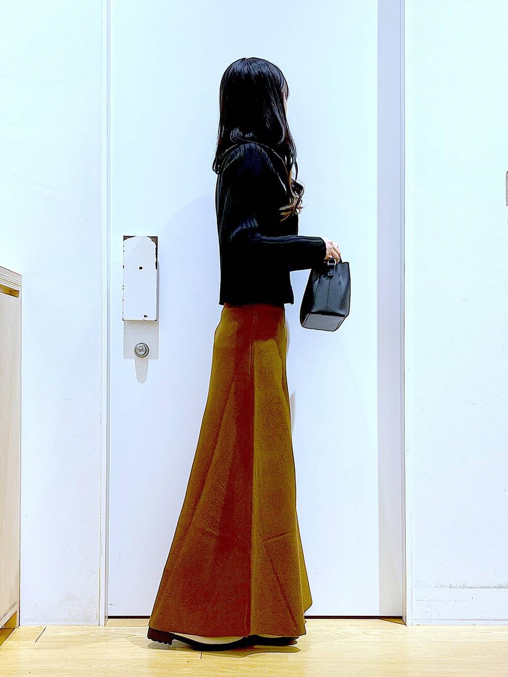 ブラック系のカーディガン/ボレロ、ブラウン系のスカート、ベージュ系のブーツを着用したレディースの冬コーディネートの4枚目の写真