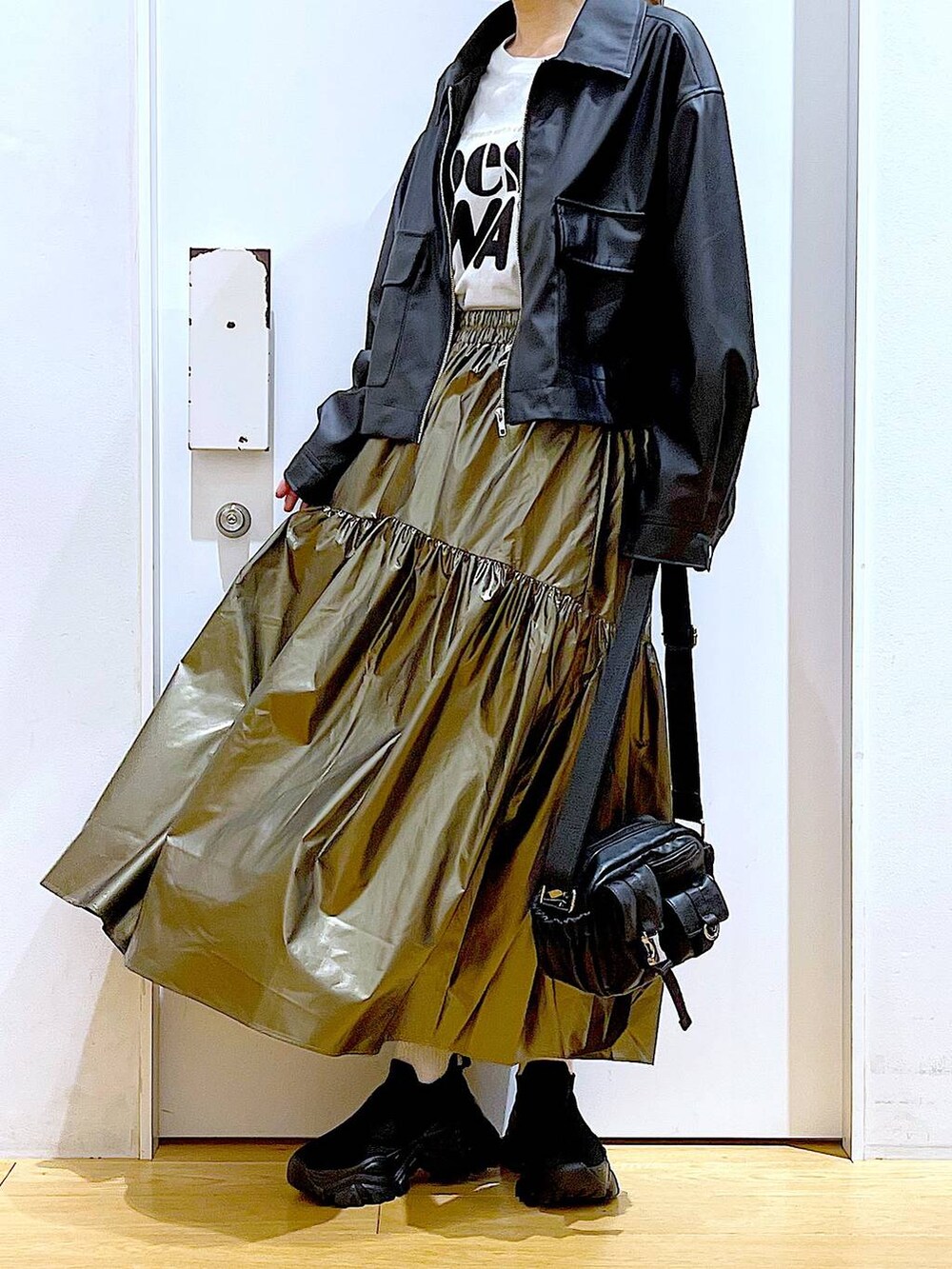 ブラック系のブルゾン、ブラック系のスニーカー、その他のスカートを着用したレディースの春コーディネートの6枚目の写真