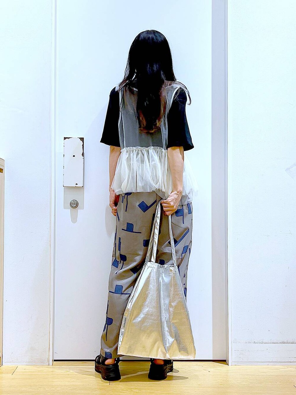 シルバー系のトートバッグ、グレー系のその他パンツ、ブラック系のサンダルを着用したレディースの夏コーディネートの5枚目の写真
