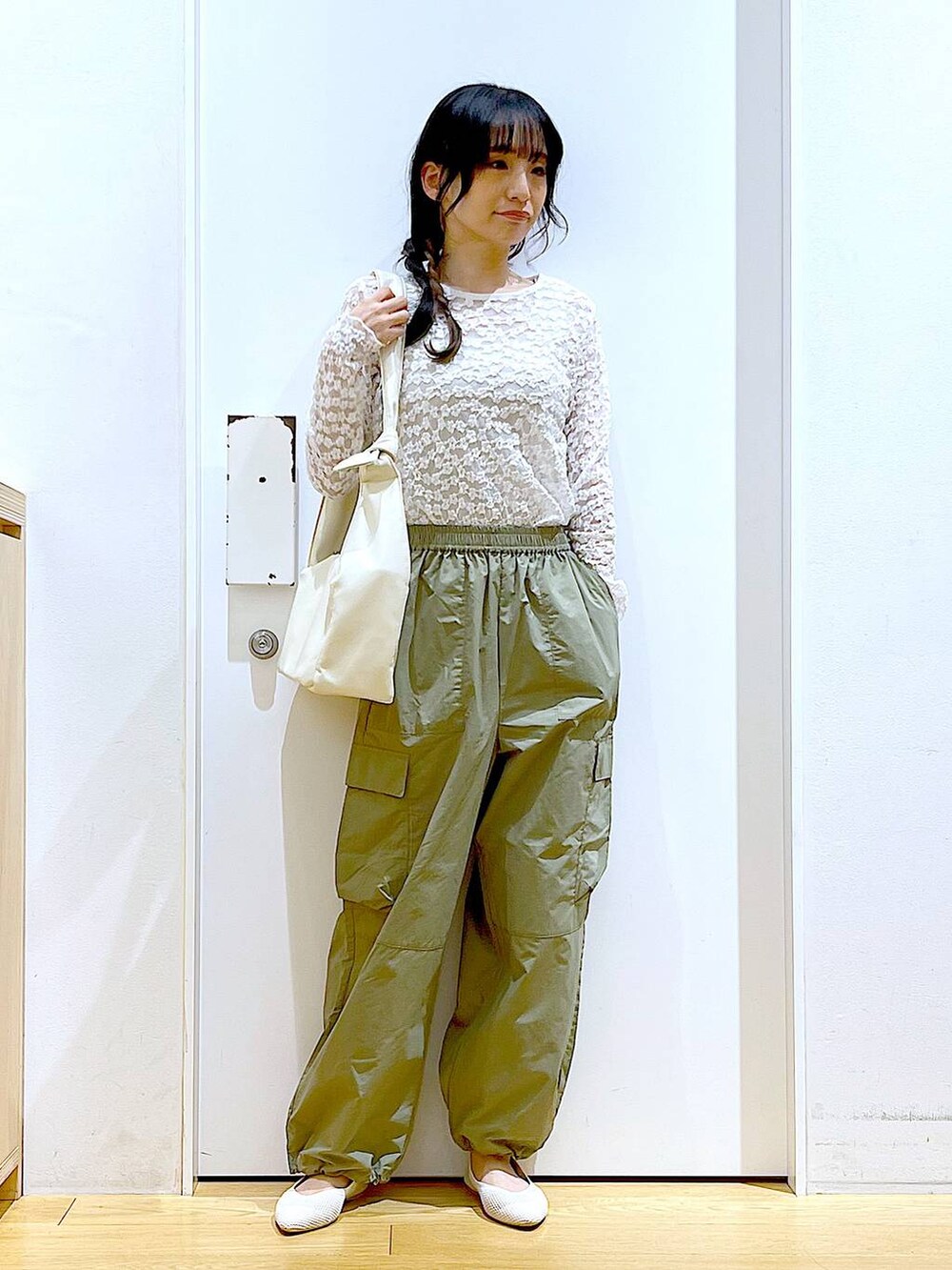 グリーン系のカーゴパンツ、ホワイト系のショルダーバッグ、ホワイト系のパンプスを着用したレディースの春コーディネートの2枚目の写真