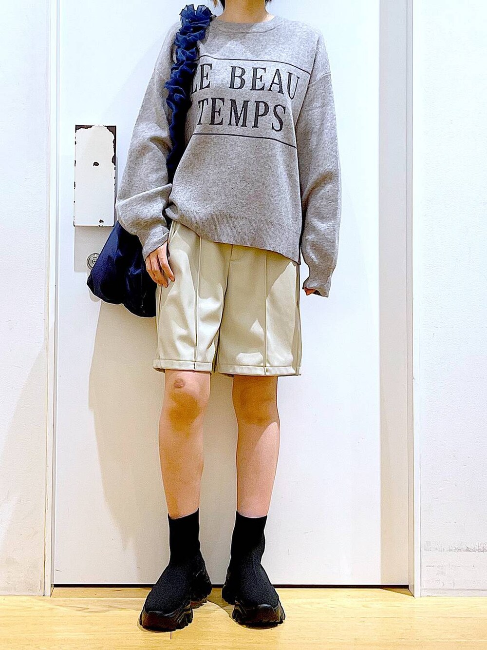 ブルー系のショルダーバッグ、ブラック系のブーツ、ベージュ系のその他パンツを着用したレディースの冬コーディネートの6枚目の写真