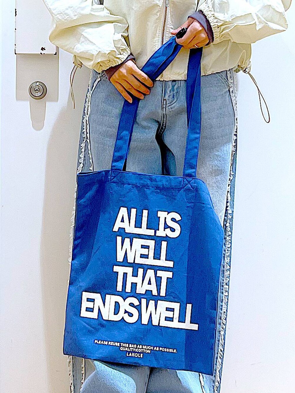 ホワイト系のスニーカー、ブルー系のデニムパンツ、ホワイト系のブルゾンを着用したレディースの春コーディネートの9枚目の写真