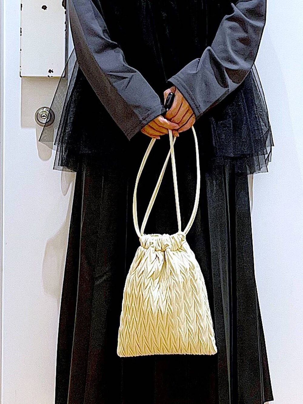 ホワイト系のショルダーバッグ、シルバー系のパンプス、ブラック系のスカートを着用したレディースの秋コーディネートの9枚目の写真