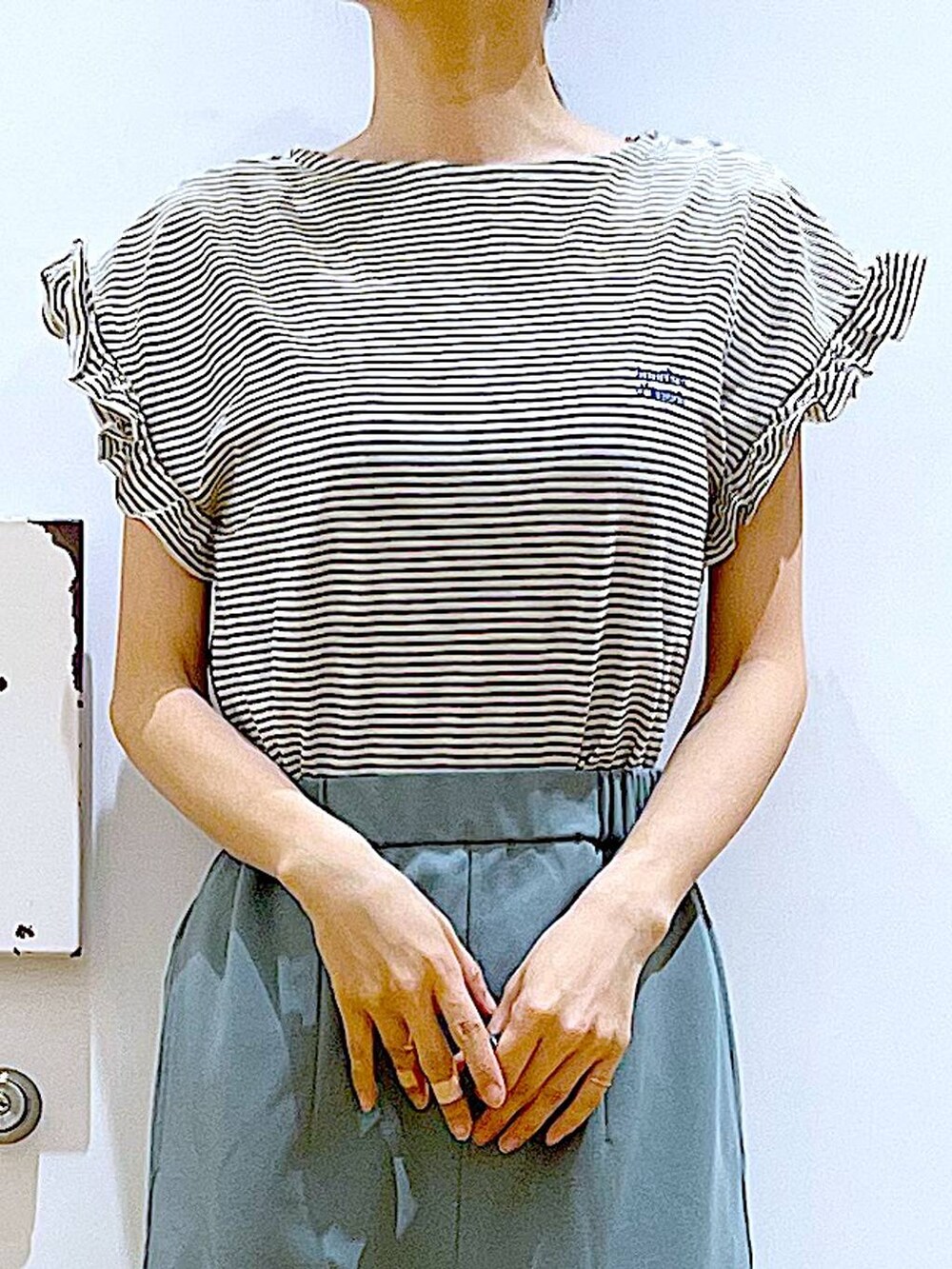 ホワイト系のショルダーバッグ、ホワイト系のパンプス、グリーン系のスカートを着用したレディースの春コーディネートの7枚目の写真