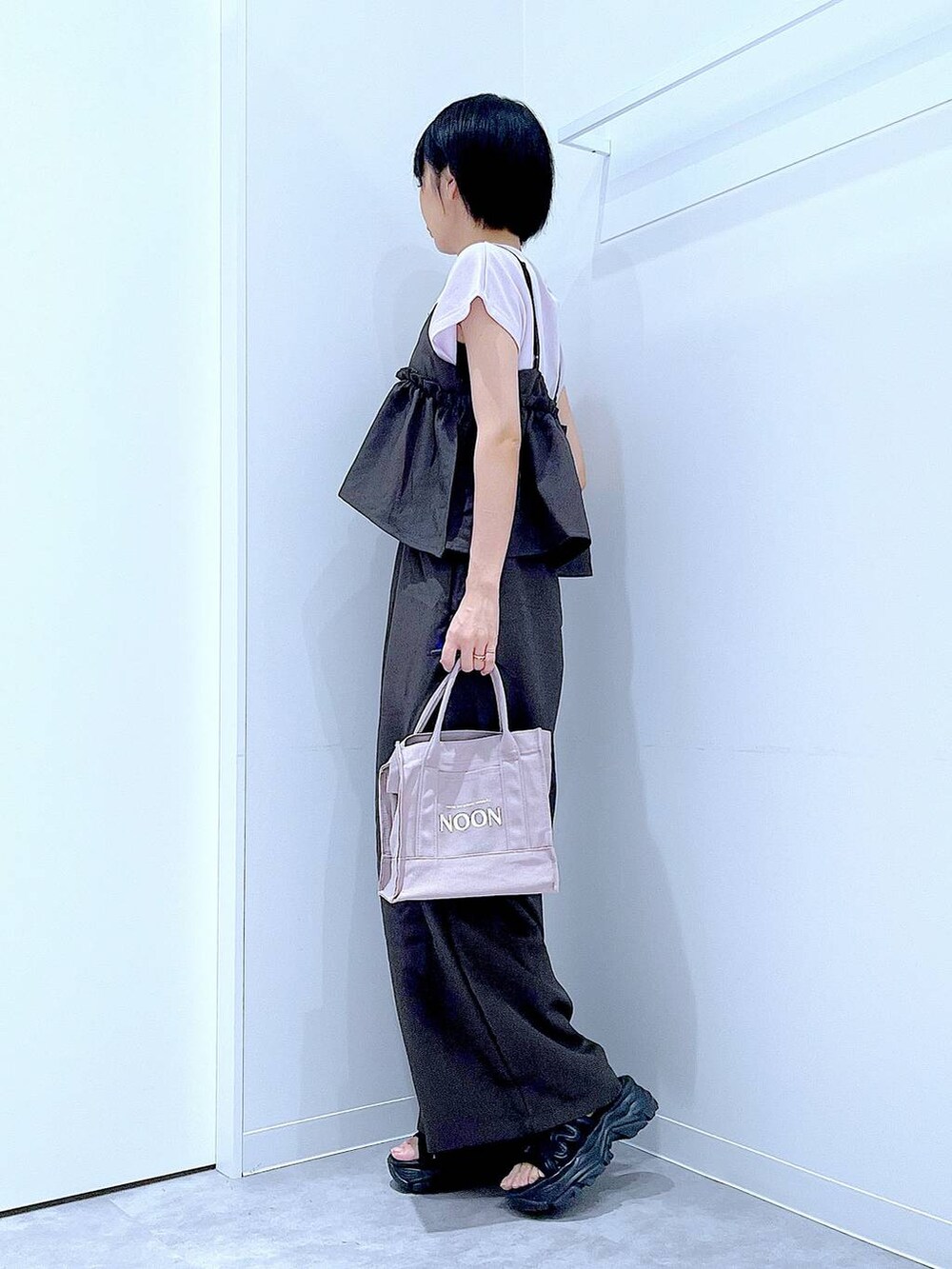 ブラック系のスニーカー、ブラック系のつなぎ/オールインワン、パープル系のTシャツ/カットソーを着用したレディースの秋コーディネートの3枚目の写真