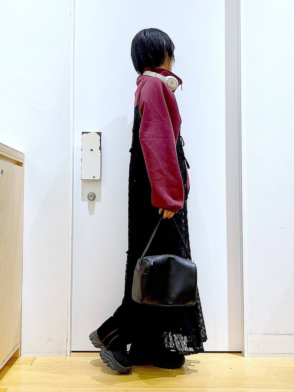 ブラック系のショルダーバッグ、ブラック系のワンピース、ブラック系のブーツを着用したレディースの冬コーディネートの4枚目の写真