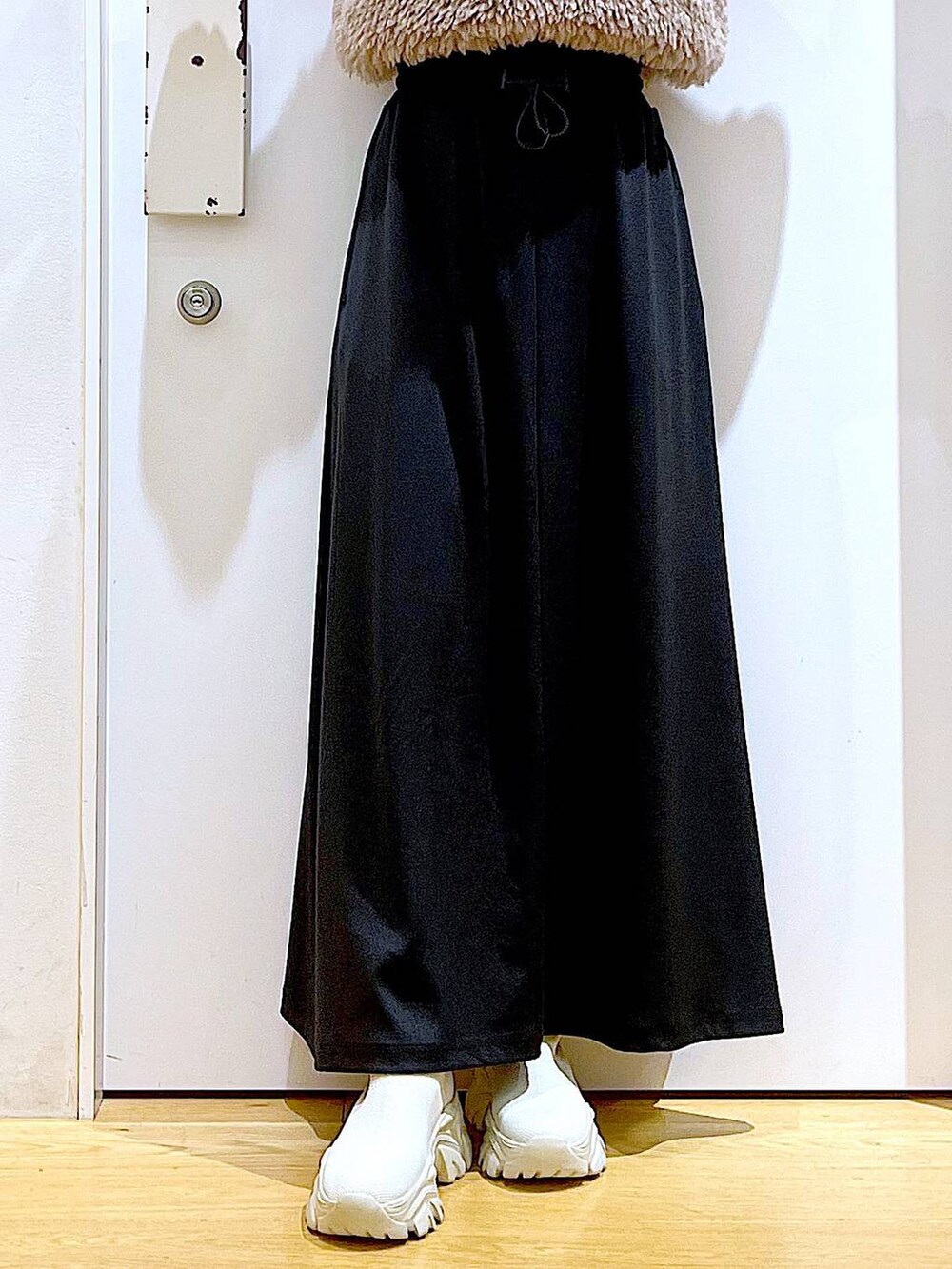 オレンジ系のニット/セーター、ブラウン系のベスト、ブラック系のハンドバッグを着用したレディースの秋コーディネートの8枚目の写真