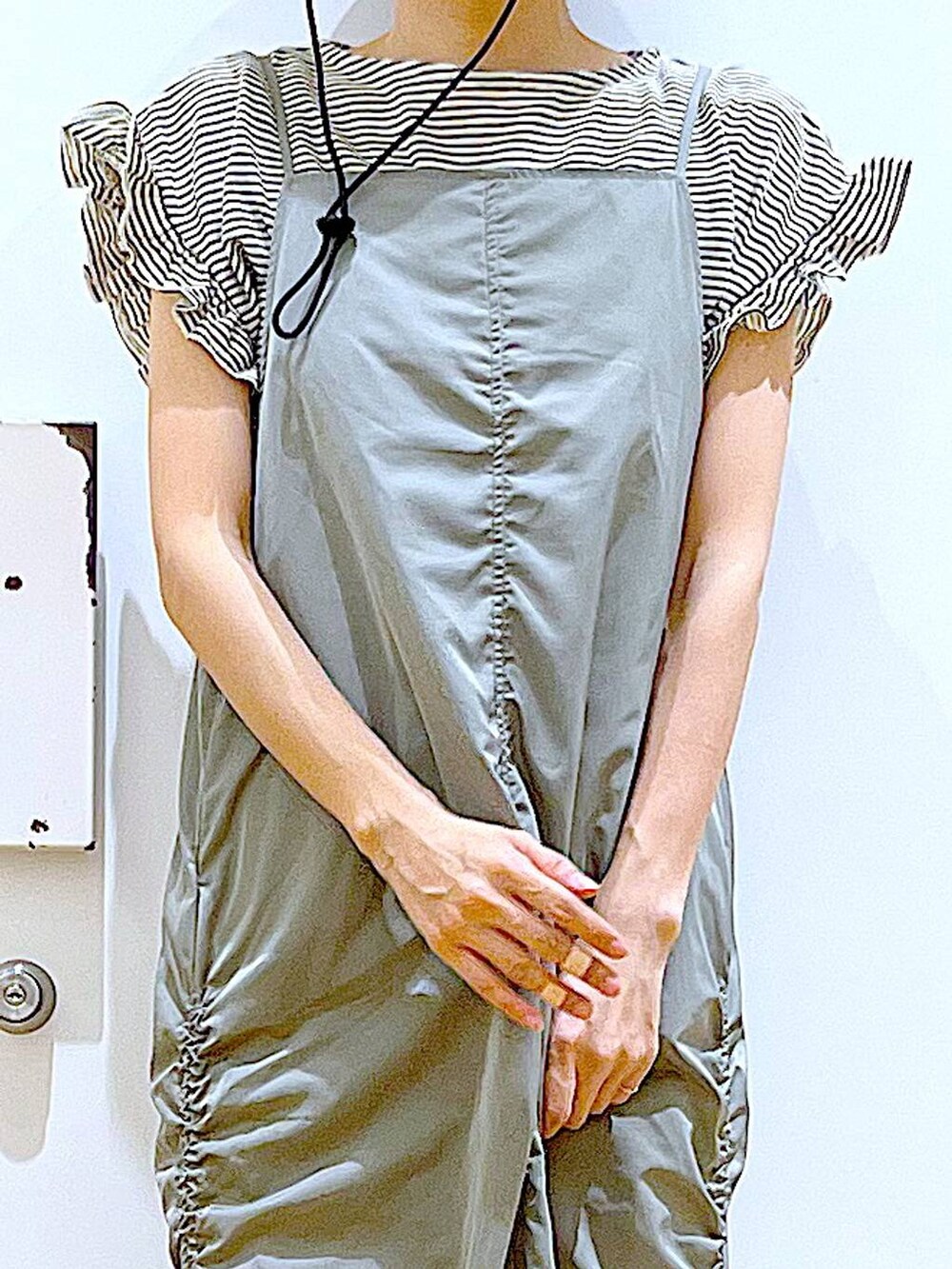 ブルー系のショルダーバッグ、ブラック系のパンプス、グリーン系のワンピースを着用したレディースの春コーディネートの7枚目の写真