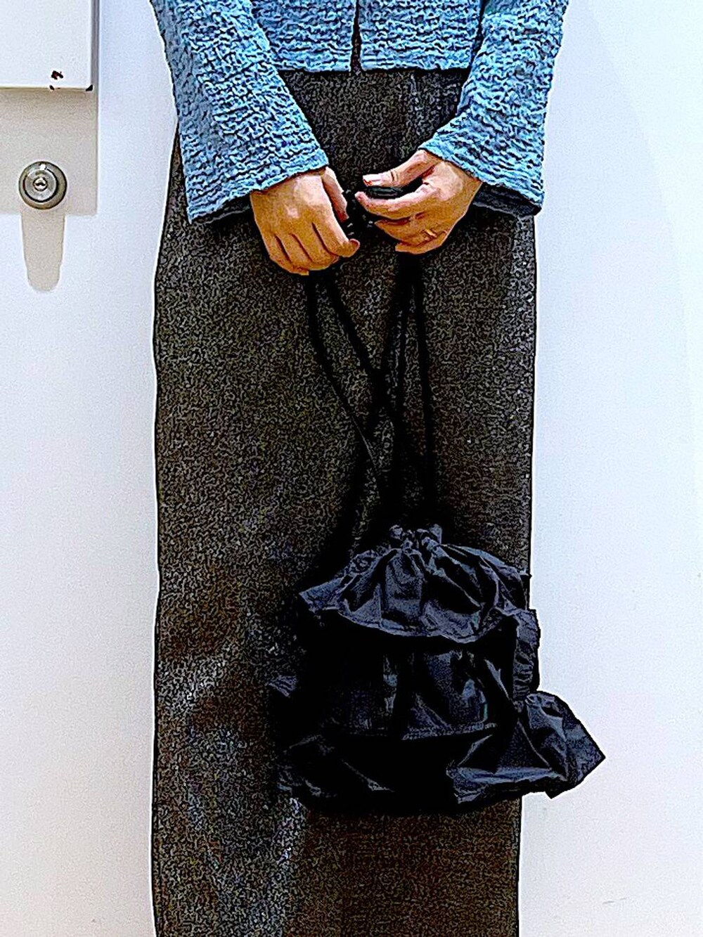 ブラック系のスカート、ブラック系のショルダーバッグ、ブラック系のパンプスを着用したレディースの春コーディネートの9枚目の写真