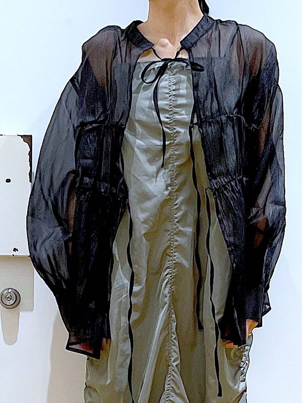 ブラック系のショルダーバッグ、ブラック系のパンプス、グリーン系のワンピースを着用したレディースの春コーディネートの7枚目の写真