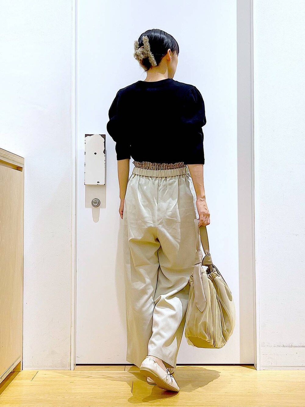 ベージュ系のトートバッグ、ホワイト系のパンプス、ブラック系のTシャツ/カットソーを着用したレディースの秋コーディネートの5枚目の写真