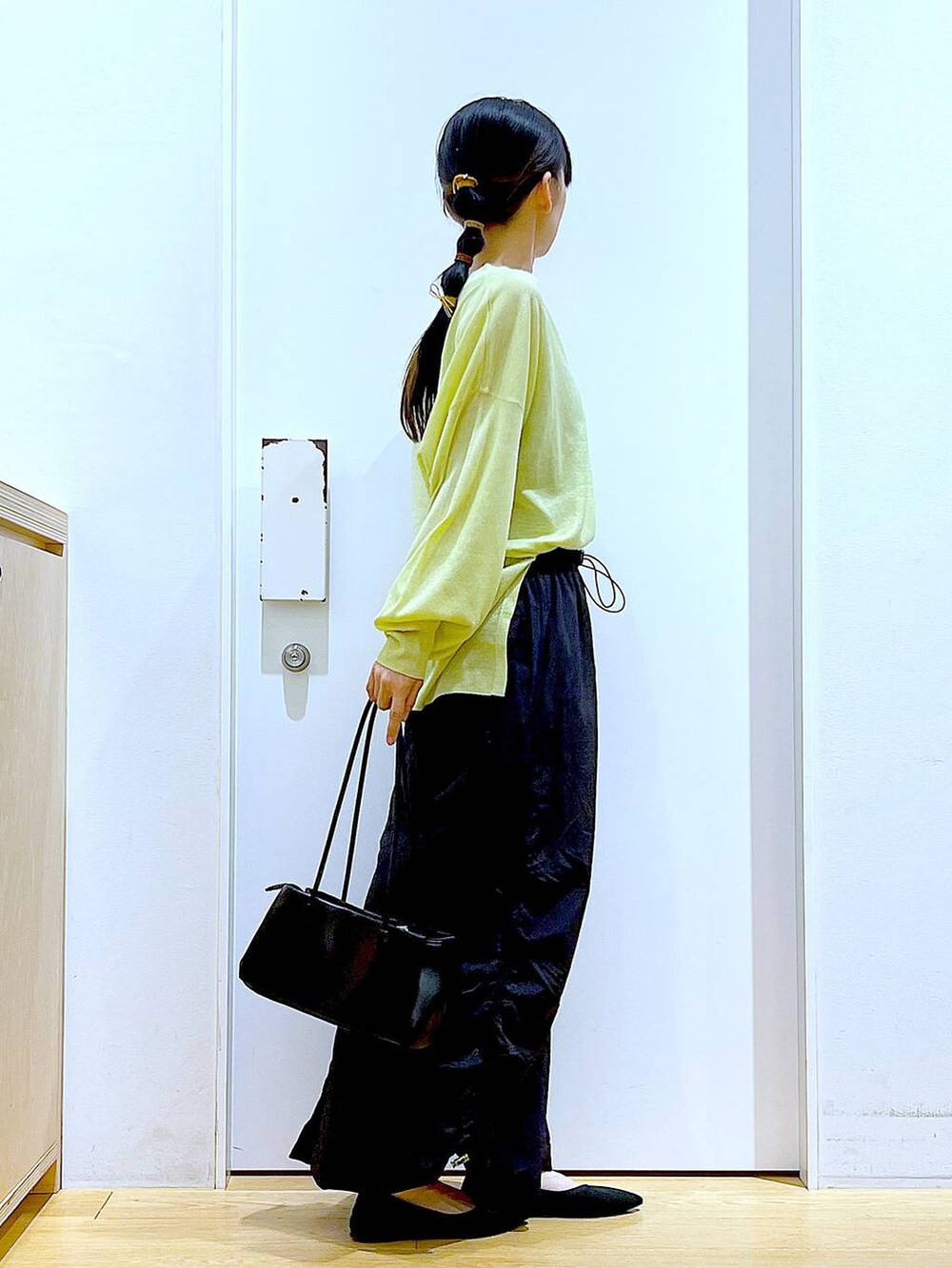 ホワイト系のキャミソール、グリーン系のカーディガン/ボレロ、ブラック系のトートバッグを着用したレディースの春コーディネートの4枚目の写真